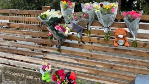 Floral tributes and teddy bears left at scene where six-year-old boy died