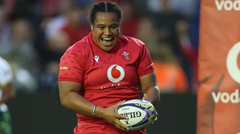 Sisilia Tuipulotu smiles as she scores a try for Wales