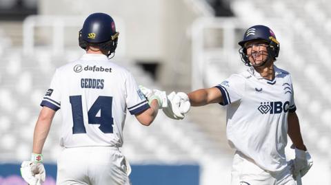 Caleb Falconer, of Middlesex, congratulates team-mate Ben Geddeson his fifty during Middlesex CCC vs Northamptonshire CCC