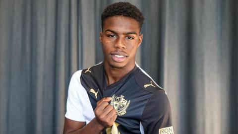 New Port Vale signing Keyrol Figueroa holds up the club's crest on his shirt during a photo-shoot as he is announced as a new signing on 1 September 2026