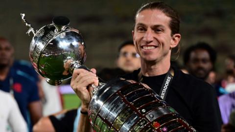 Filipe Luis poses with the Copa Libertadores trophy