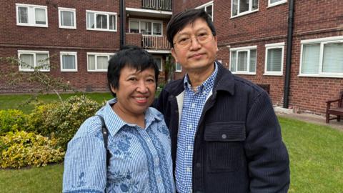 Su Su Myat and Justin King standing outside the block of flats.