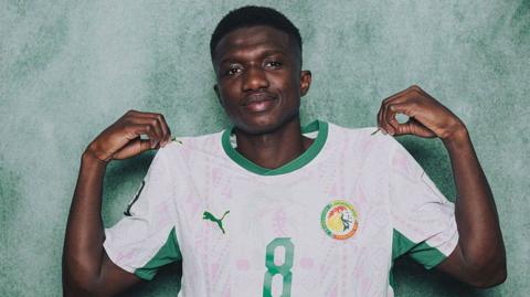 Lamine Camara pinches his shirt