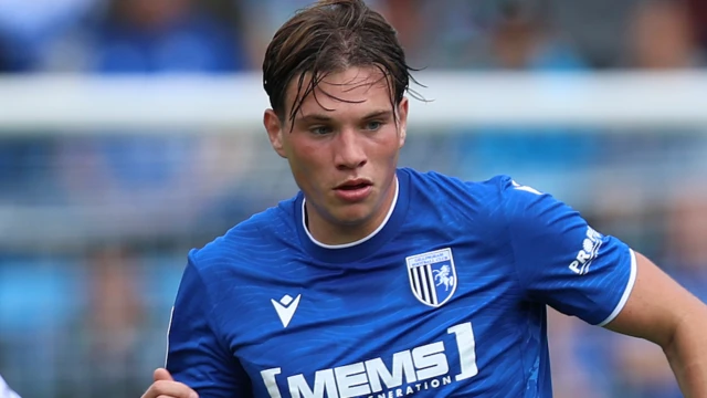 Logan Dobbs playing in the blue home kit of Gillingham