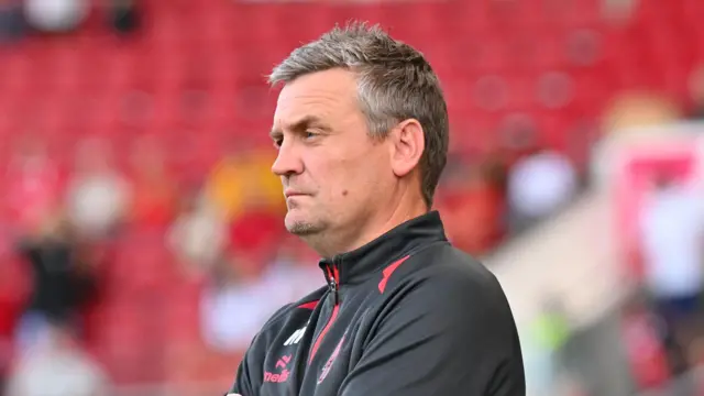 Michael Skubala wears a black hoodie with red accents as he watches his Bristol City team in August