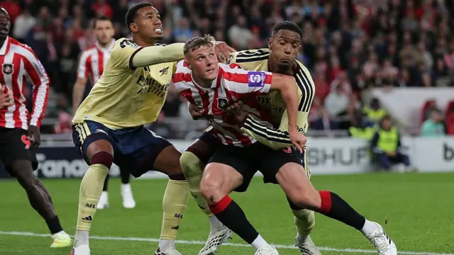 Arsenal's Ezri Konsa has two arms around the waist of Dan Ballard of Sunderland leading to a penalty kick