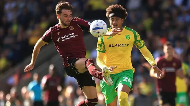 Max Conway of Bolton challenges Jovon Makama of Norwich for a bouncing ball