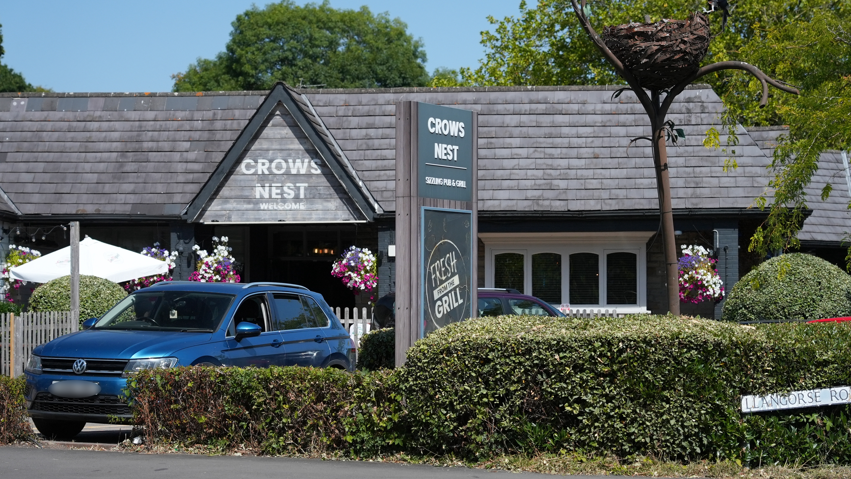 The Crow's Nest Pub exterior with a blue car parked in front of the entrance.