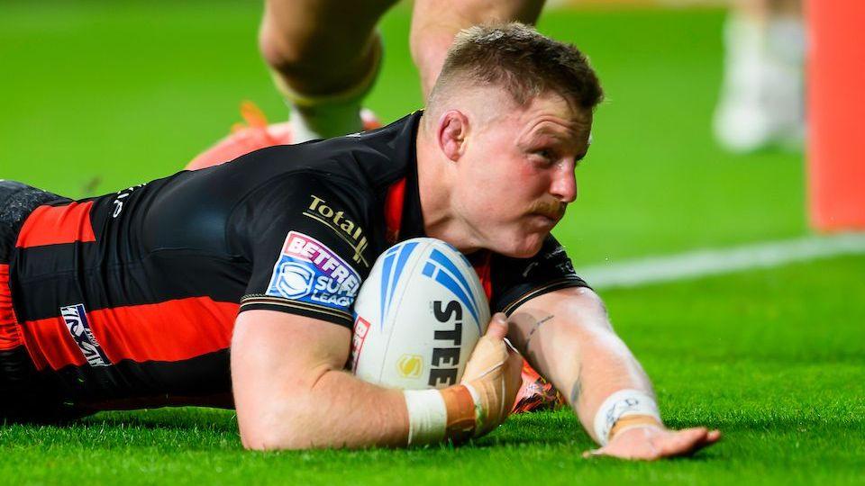 Warrington Wolves' Luke Yates sliding with the ball in his right hand to score for his side against Leeds Rhinos 