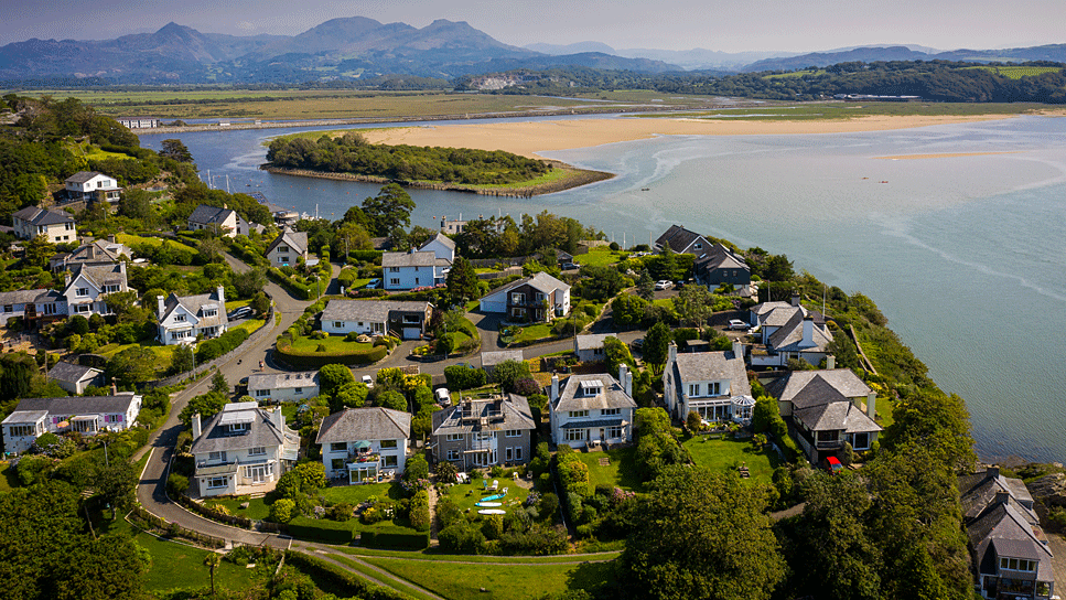 Aerial view of homes overlooking Welsh coast and mountains surrounding Porthmadog