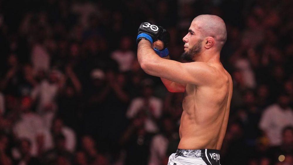 Muhammad Mokaev is shirtless and holding up his hands