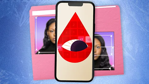 A stylised graphic of a red blood drop containing an eye, displayed on a smartphone screen. Parts of a woman's face are seen on a file folder behind the smartphone (Credit: BBC/ Serenity Strull/ Getty Images)
