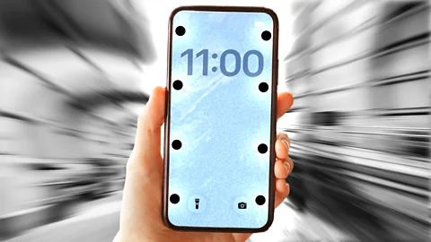 Hand holding a smartphone with big dots on the edges of the screen