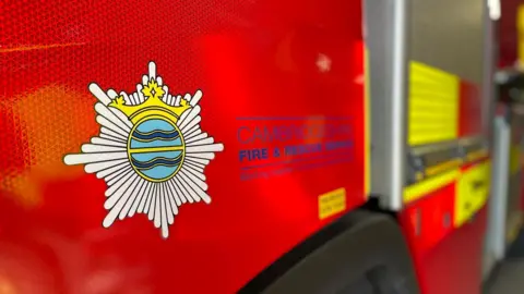 A red and yellow fire engine, featuring an emblem and the words "Cambridgeshire Fire & Rescue Service".