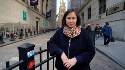 Michelle Fleury stands on the Wall Street.