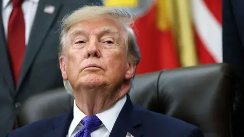 US President Donald Trump listens to a reporters question in the Oval Office at the White House 