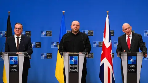 Getty Images Germany's Defence Minister Boris Pistorius, Ukraine's Minister of Defence Rustem Umerov and Britain's Defence Secretary John Healey hold a press conference following a Ukraine Defence Contact Group meeting at the Nato headquarters in Brussels, on April 11, 2025