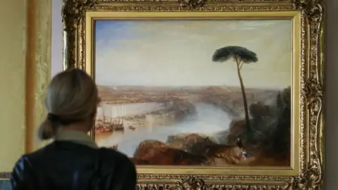 A person stands in front of William Turner’s 1835 painting “Rome, from Mount Aventine”