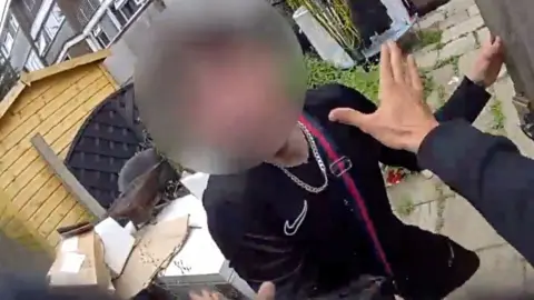 Man with blurred face and the hands of policeman ready to arrest him