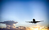 The silhouette of a plane as it rises through the evening sky
