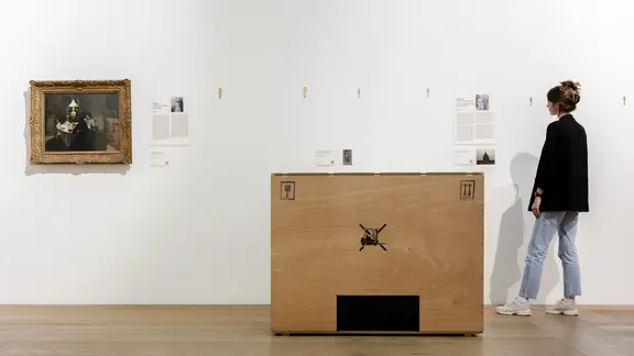 Eine Frau betrachtet eine Informationstafel im Museum