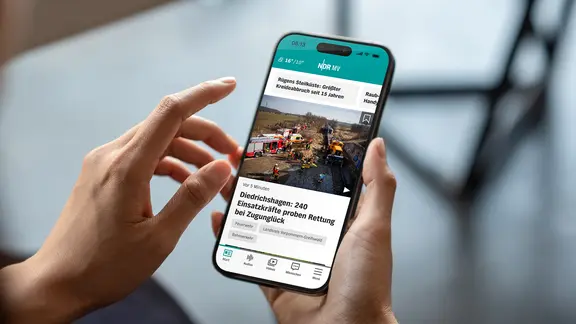 Eine Hand hält ein Handy in der Hand. Darauf ist die NDR MV App geöffnet.