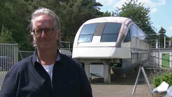 Dirk Dinnus neben einem alten ausgestellten Transrapid.