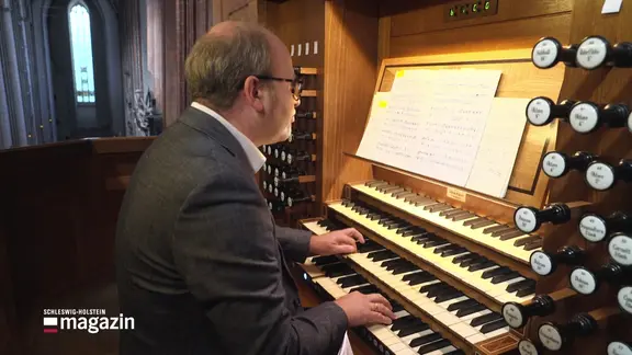 Ein Mann spielt auf einer Kirchenorgel.