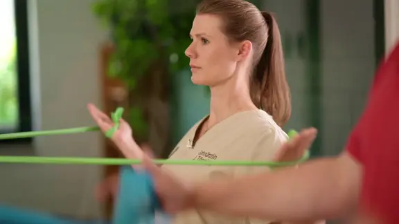 Eine Frau trainiert mit einem Gymnastikband.