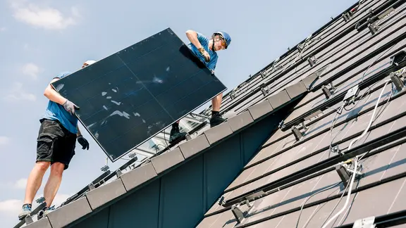 Handwerker installieren eine Solaranlage auf einem Dach