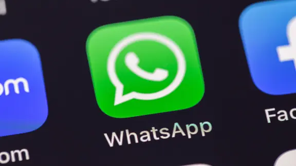 Das WhatsApp-Logo auf einem schwarzen Smartphone-Display. 