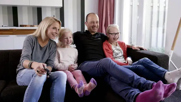 Eine Familie sitzt auf einem Sofa.