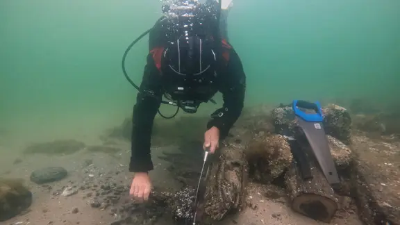 Ein Forschungstaucher begutachtet Wrackteile am Grund des Greifswalder Boddens.