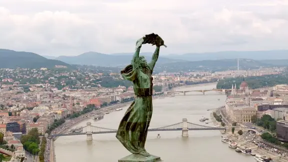 Die Statue einer Frau steht weit oben über der Hauptstadt Budapest.