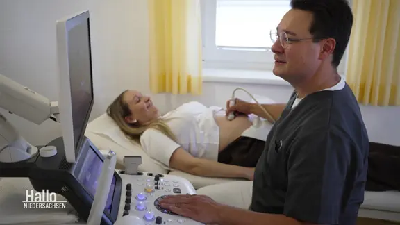 Frauenarzt führt eine Ultraschalluntersuchung bei einer schwangeren Frau durch.