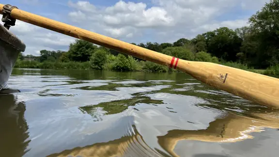 Das Paddel eines Ruderboots wird durchs Wasser gezogen (Archiv-Bild).