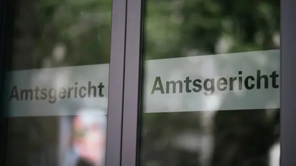 Eine gläserne Schiebtür ist mit dem Schriftzug Amtsgericht beklebt.
