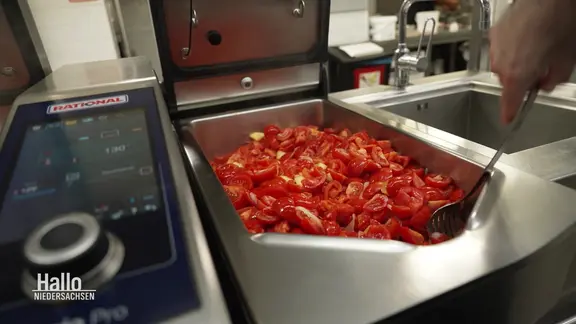Tomatensalat in einem Behälter in einer Großküche 