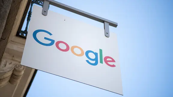 Ein Schild mit der Aufschrift "Google" hängt vor einem Schulungsraum der Firma.