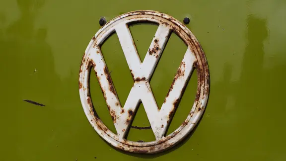 Rostiges VW Logo an einem VW Bulli Oldtimer