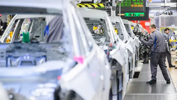 Niedersachsen, Wolfsburg: Mitarbeiter arbeiten im VW Stammwerk im Karosseriebau an Neuwagen