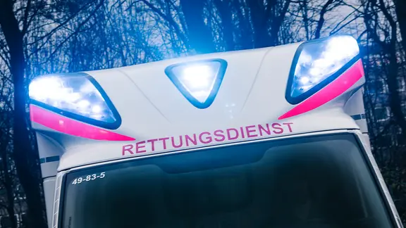 Über der Frontscheibe eines Rettungswagens blinkt das Blaulicht.