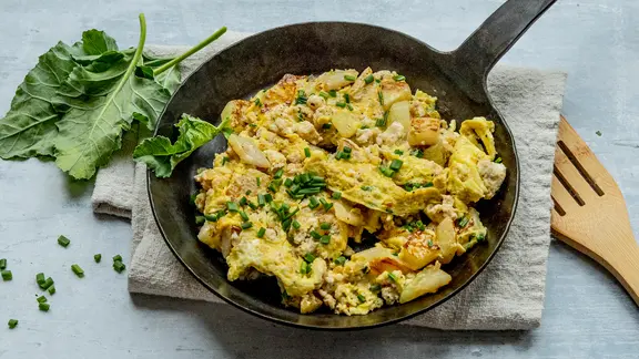 Eine Pfanne mit einem Kohlrabi-Bauernfrühstück mit Hähnchenhack.