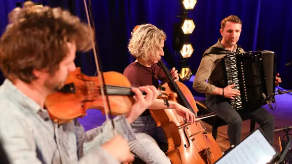 Matthias Well an der Geige, Maria Well sitzt zwischen den Männern am Cello und ganz rechts sitzt Vladislav Cojocaru am Akkordeon.