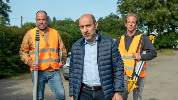 Heinrich Rückert (Yaşar Çetin mit Komparsen) stößt mit seinem Bauvorhaben im Kleingartenverein auf heftigen Widerstand.