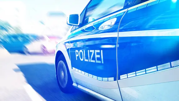 Nahaufnahme eines deutschen Polizeiwagens mit Blaulicht auf der Straße