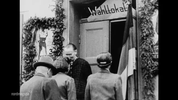 Menschen vor dem Wahllokal.