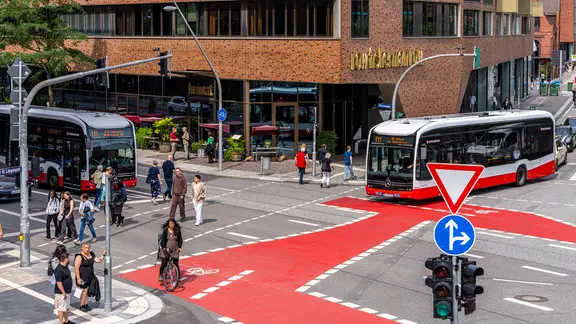 Eine Kreuzung in der Hamburger Hafencity mit Radfahrern und, Fußgängern und Bussen.