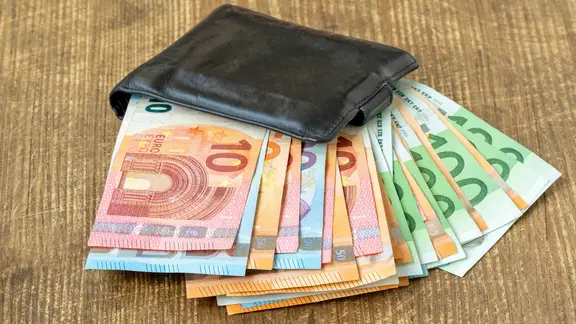 Euro-Banknoten ragen aufgefächert aus einem schwarzen Portemonnaie.