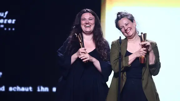 Regisseurin Mascha Schilinski (links) und Louise Peter halten deutsche Filmpreise (Lolas) in den Händen für "In die Sonne schauen"